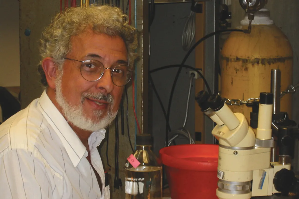 Dr. Macagno is pictured seated with a microscope